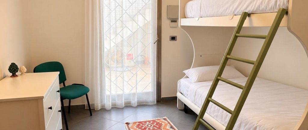 Second bedroom with bunk beds and a door to the courtyard