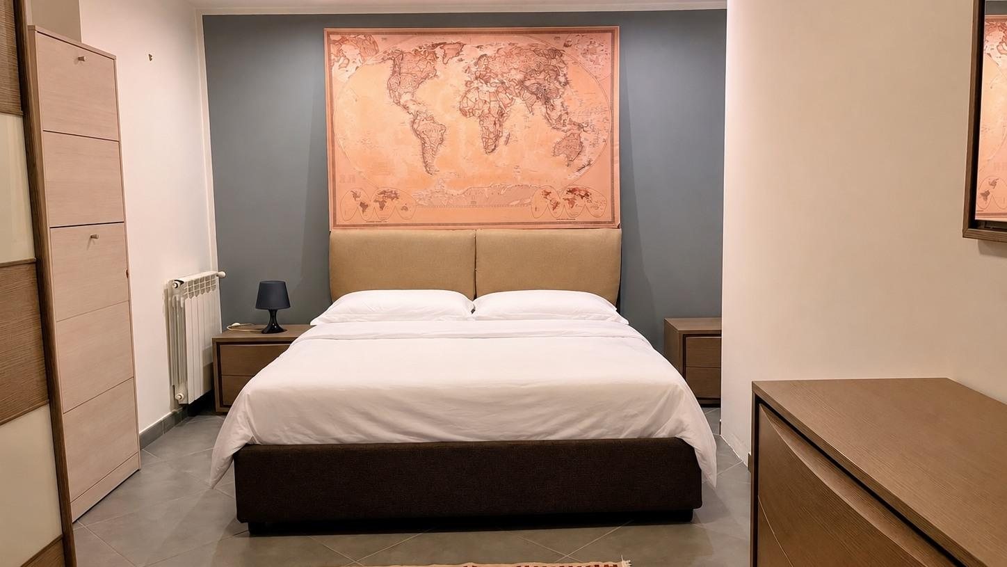Double bedroom with world map above the bed