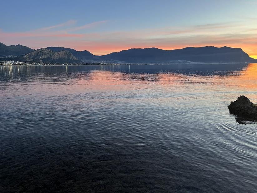 The bay at dusk with mountains along the coast