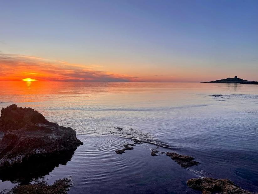 Sunset over the sea with the islet and its watchtower